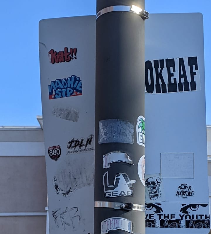 Photo of stickers on the back of a sign.